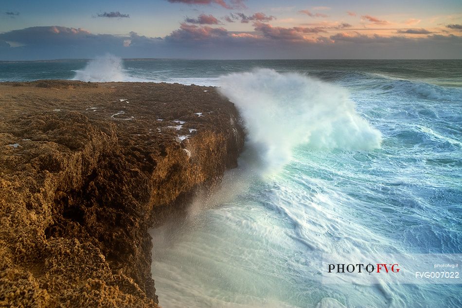 The waves break on the rocks at Capo Mannu during rough seas mistral