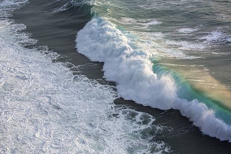 The sun at sunset, illuminates the waves crashing against the cliffs of Capo Nieddu The sun at sunset, illuminates the waves crashing against the cliffs of Capo Nieddu