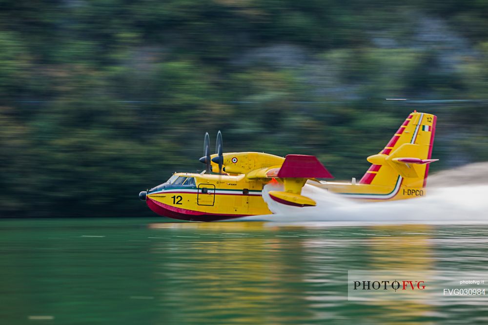 Firefighting airplane, Bombardier 415 - Canadair CL-415, taking water from the Lake, Somplago, Cavazzo Carnico, Udine, Italy. 