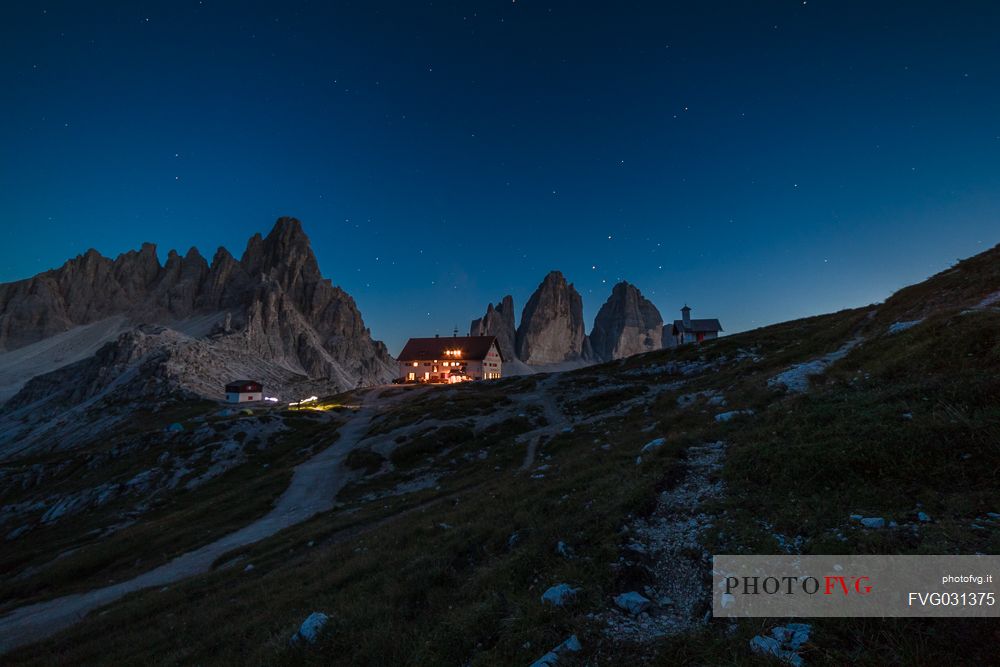 The north faces of the Tre Cime di Lavaredo peak and the Rifugio Locatelli hut at twilight, Sexten Dolomites, Trentino Alto Adige, Italy.