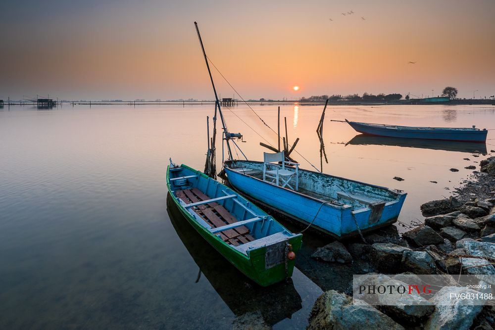 Typical fishing boats in Comacchio lagoon at sunset, Ferrara, Emilia Romagna, Italy