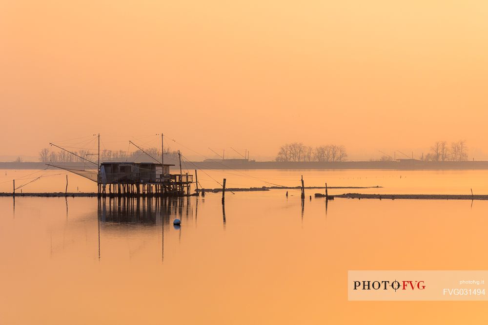 Typical fishing house called Padellone or Bilancione in Comacchio lagoon at sunset, Ferrara, Emilia Romagna, Italy