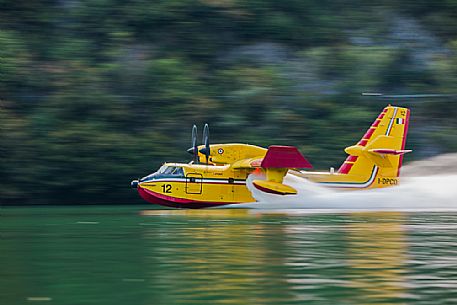 Firefighting airplane, Bombardier 415 - Canadair CL-415, taking water from the Lake, Somplago, Cavazzo Carnico, Udine, Italy. 