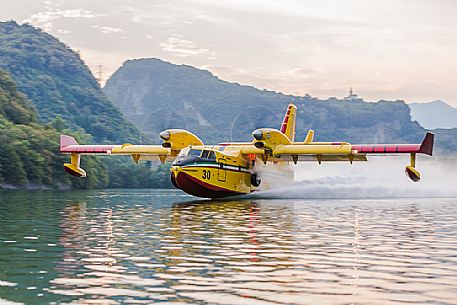 Firefighting airplane, Bombardier 415 - Canadair CL-415, taking water from the Lake, Somplago, Cavazzo Carnico, Udine, Italy. 