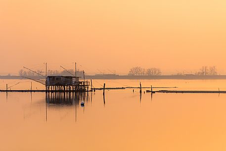 Typical fishing house called Padellone or Bilancione in Comacchio lagoon at sunset, Ferrara, Emilia Romagna, Italy