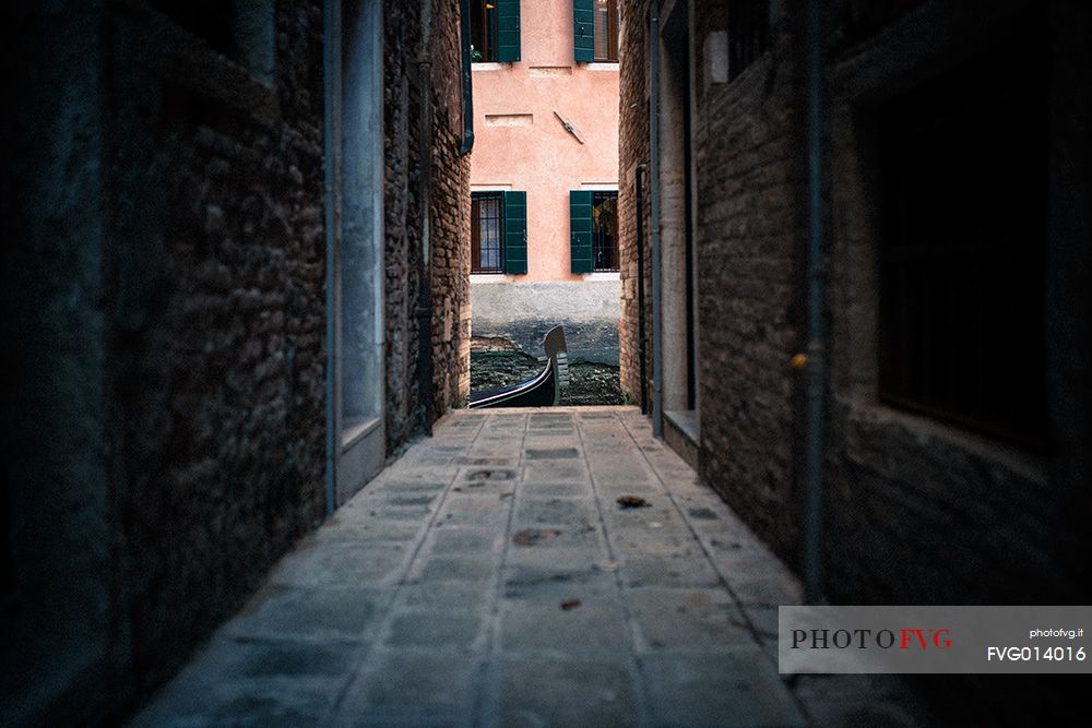 Detail of gondola on the canal from a dark calle, Venice, Italy, Europe