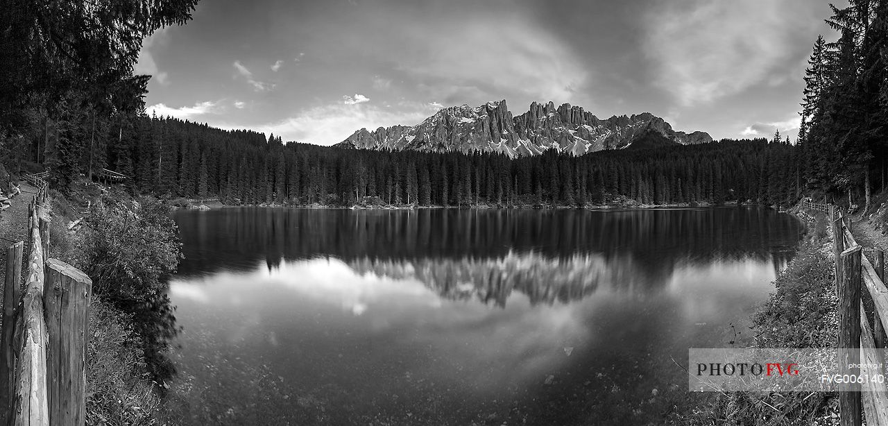 The Latemar is reflected in the Carezza Lake at sunset