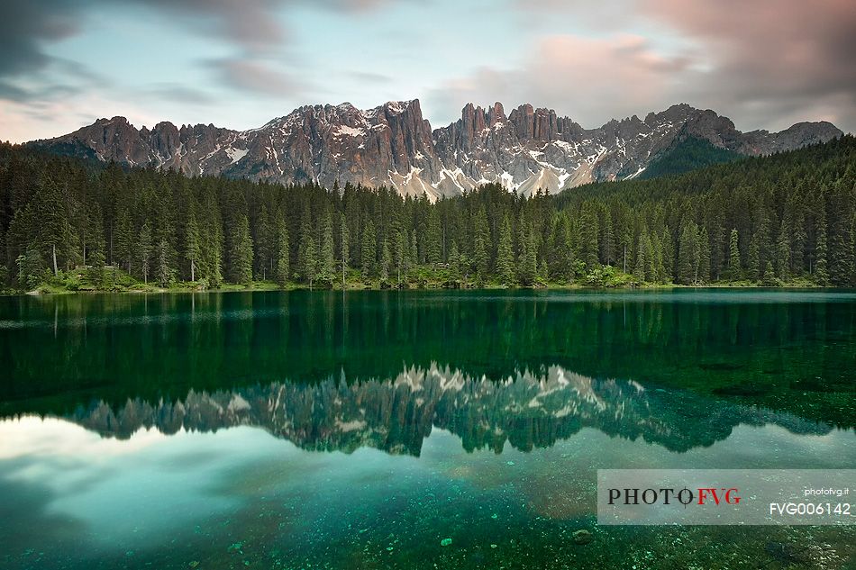 The Latemar is reflected in the Carezza Lake at sunset