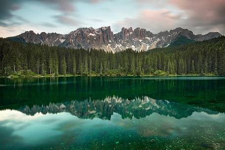 The Latemar is reflected in the Carezza Lake at sunset