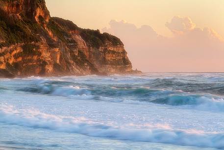 The symphony of the waves and the golden light of sunset in the Bay Statues in Santa Sunday fall during a violent storm