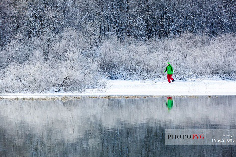 Hiker at Fusine lake in a winter landscape, Tarvisio, Julian Alps, Italy