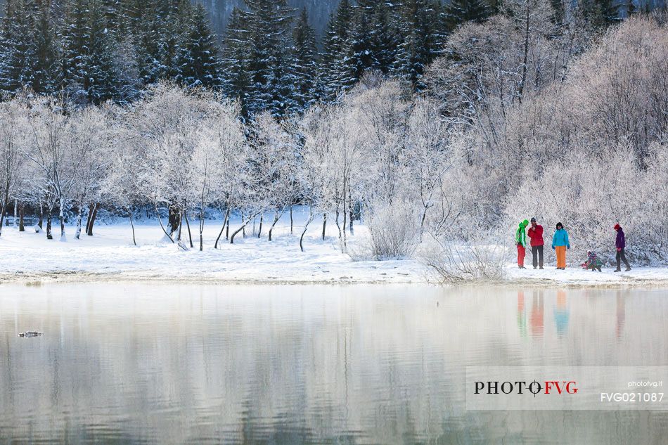 Hiker at Fusine lake in a winter landscape, Tarvisio, Julian Alps, Italy