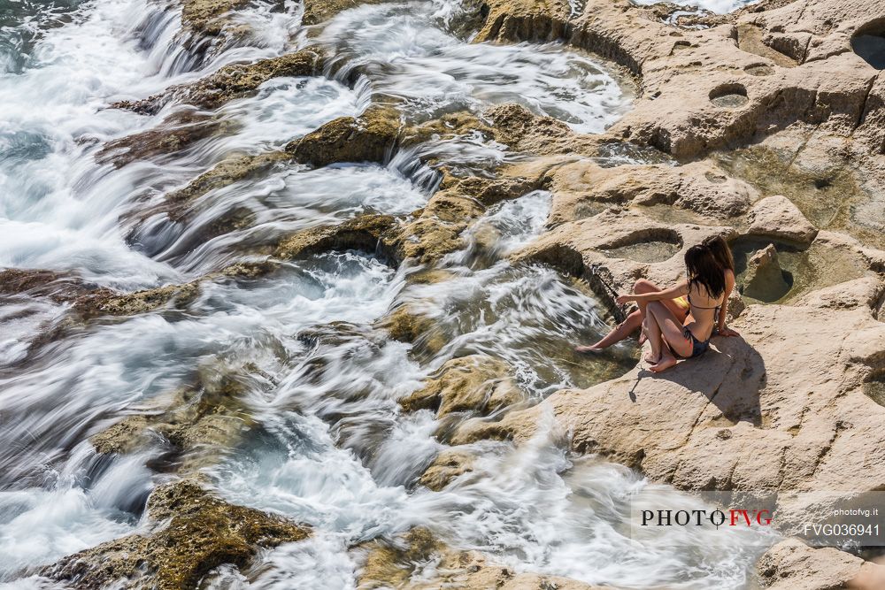 Summer holiday on the rocky coast of St. Peter's Pool, one of the most beautiful natural pools on the island of Malta, Europe