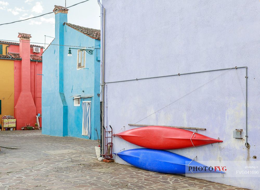 Canoes hanging on the wall of the colorful Burano village, Venice, Italyl, Europe