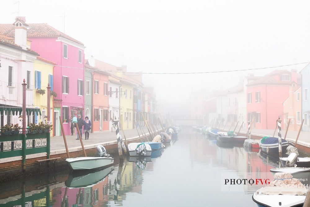 Colorful houses in Burano with canal and moored boats in the fog, Venice, Venetian lagoon, Veneto, Italy, Europe