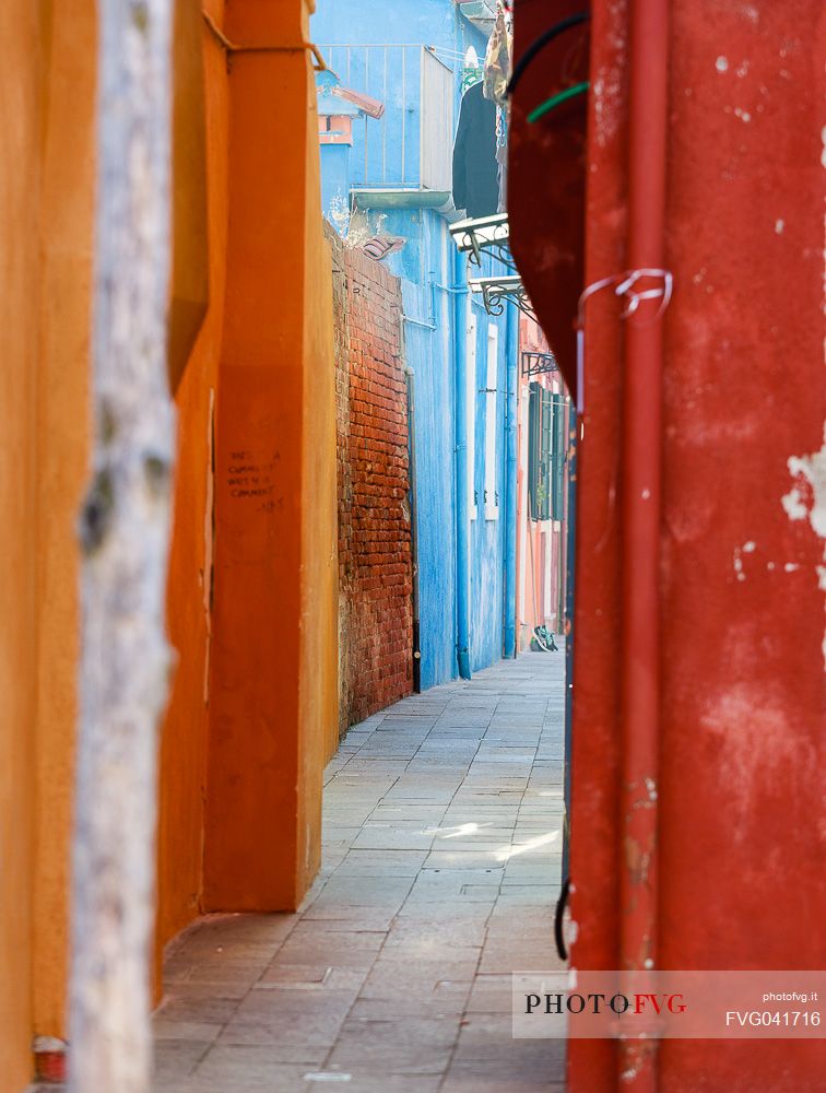 The colored houses in a typical alley of Burano village, Venice, Italyl, Europe