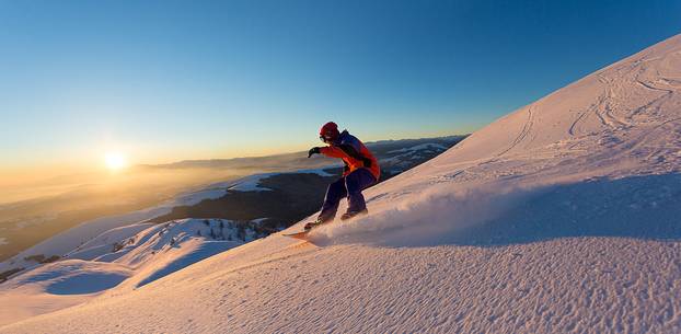 Snowboarding on Mount Grappa at sunset