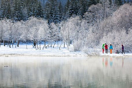 Hiker at Fusine lake in a winter landscape, Tarvisio, Julian Alps, Italy