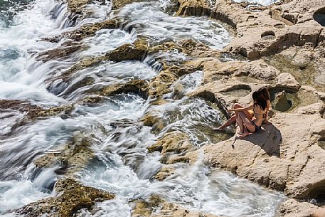 Summer holiday on the rocky coast of St. Peter's Pool, one of the most beautiful natural pools on the island of Malta, Europe