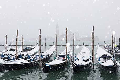 Winter snowfall in the city of Venice, gondolas covered by snow and in the background the San Giorgio Maggiore church, Venice, Veneto, Italy, Europe