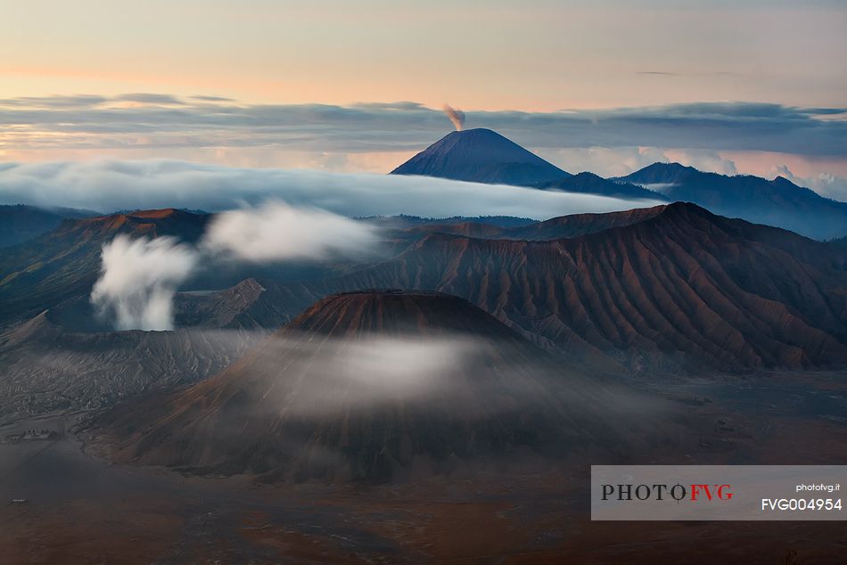 A primordial sunrise of smoking volcanoes of Bromo Tengger Semeru National Park, Isle of Java.