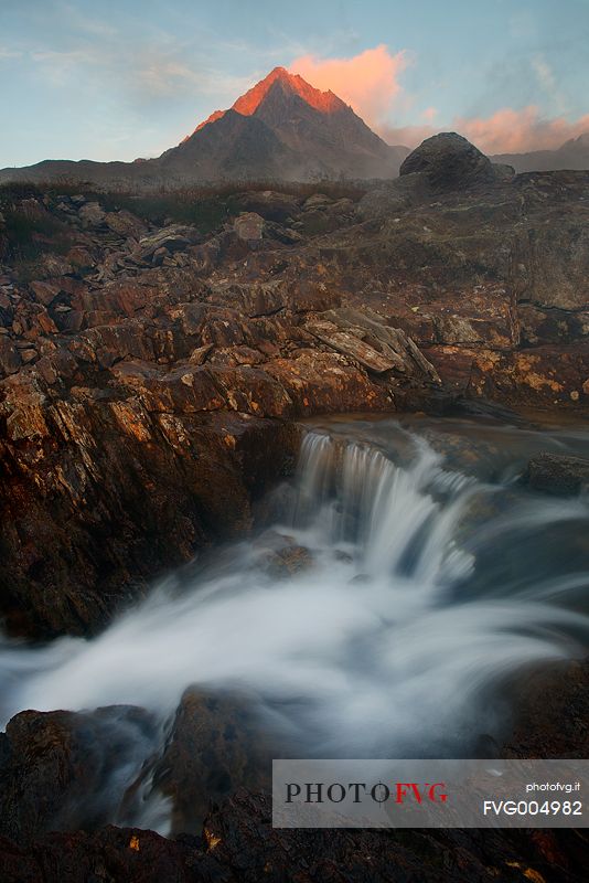 Mountain peak and river at sunset, Stelvio National Park, italian Alps.