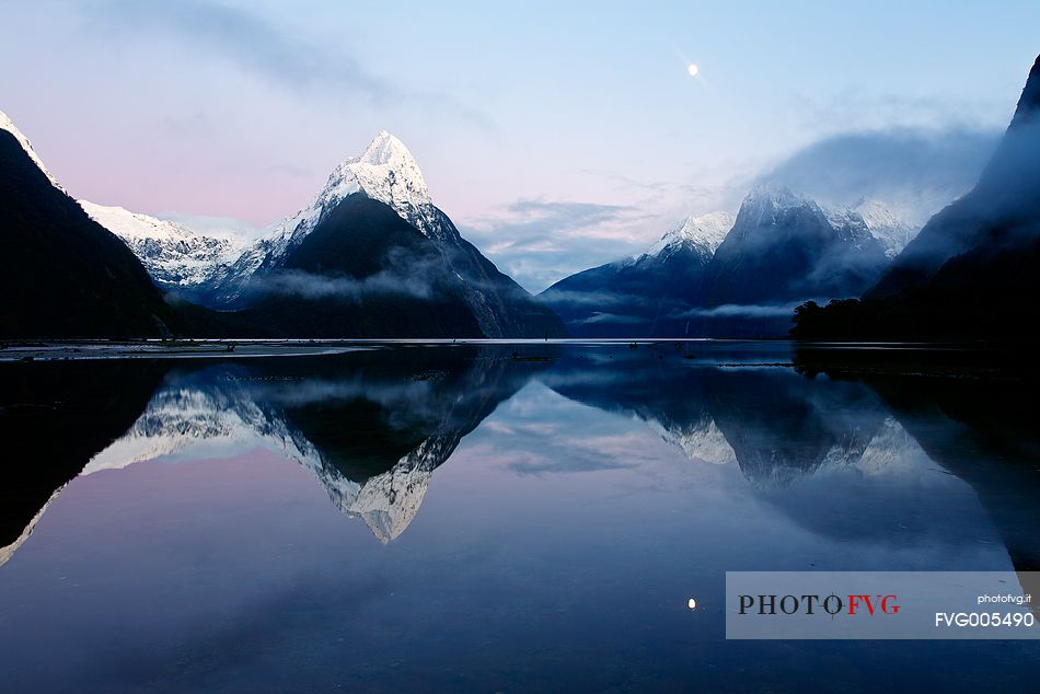 Milford Sound and moon during a cold and misty sunrise.