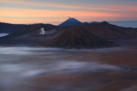 A primordial sunrise of smoking volcanoes of Bromo Tengger Semeru National Park, Isle of Java. A primordial sunrise of smoking volcanoes of Bromo Tengger Semeru National Park, Isle of Java.