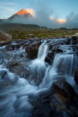 Mountain peak and river at sunset, Stelvio National Park, italian Alps.