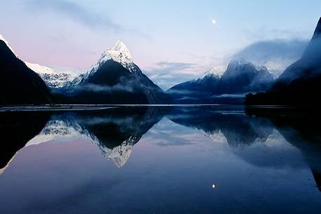 Milford Sound and moon during a cold and misty sunrise.