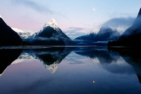 Moon and snow capped peaks reflected on the sound during an amazing sunrise in Fiorland Region. Moon and snow capped peaks reflected on the sound during an amazing sunrise in Fiorland Region.