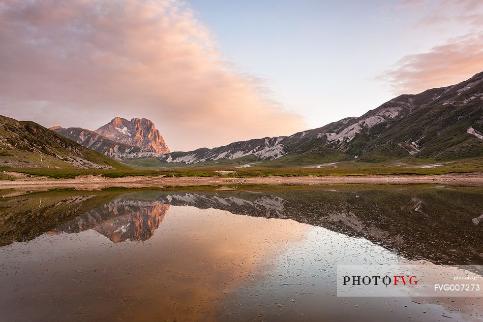 The Corno Grande peak, reflected on the Pietranzoni lake in summer evening