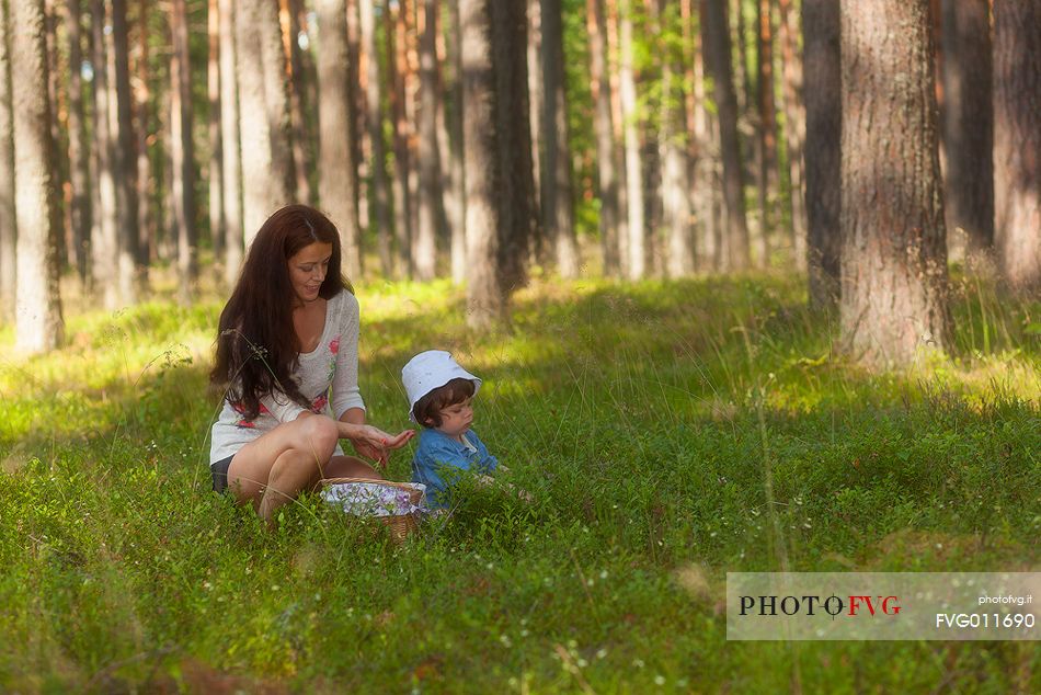 mother and son in the wild blueberry forest