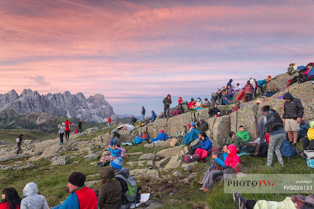 Sounds of the Dolomites, the high altitude music festival in Trentino.  At Sunrise many people listen to a concert on Col Margherita with Pale di San Martino Dolomites in background, dolomites, Italy