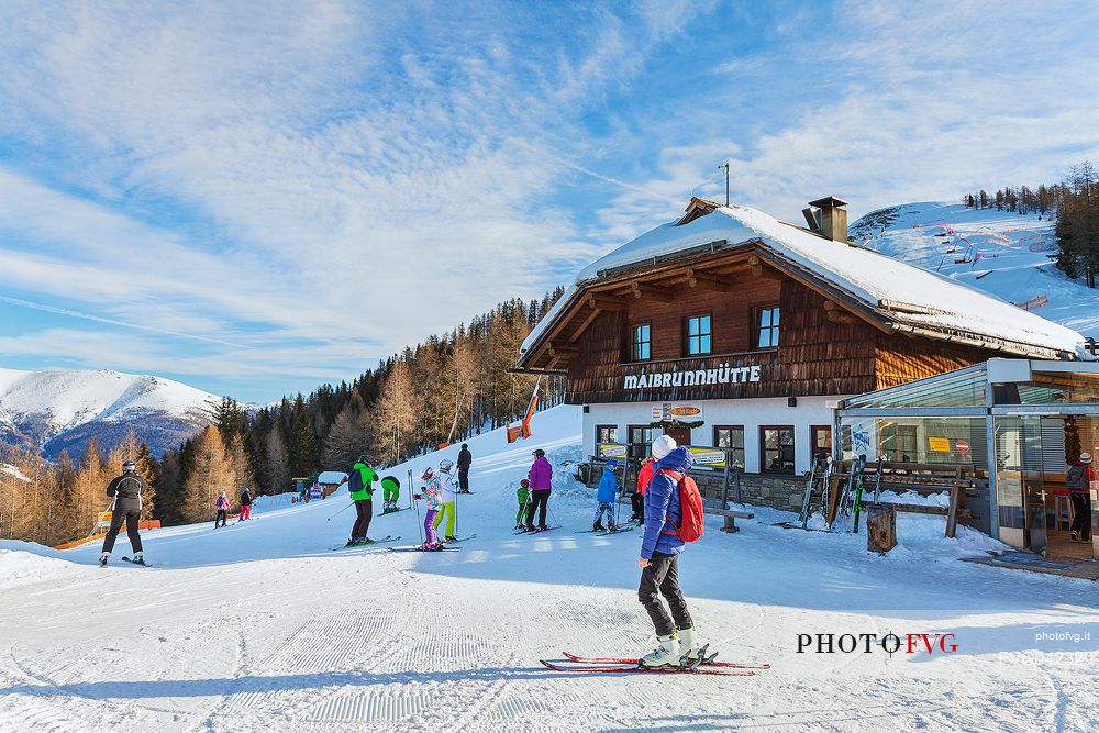 Skiers in front of Maibrunnhtte mountian hut on the top of Maibrunnbahn alpine station, Bad Kleinkirchheim, Carinthia, Austria, Europe