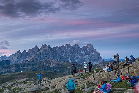 Sounds of the Dolomites, the high altitude music festival in Trentino.  At Sunrise many people listen to a concert on Col Margherita with Pale di San Martino Dolomites in background, dolomites, Italy