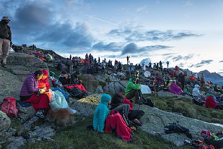 Sounds of the Dolomites, the high altitude music festival in Trentino.  At Sunrise many people listen to a concert on Col Margherita with Pale di San Martino Dolomites in background, dolomites, Italy