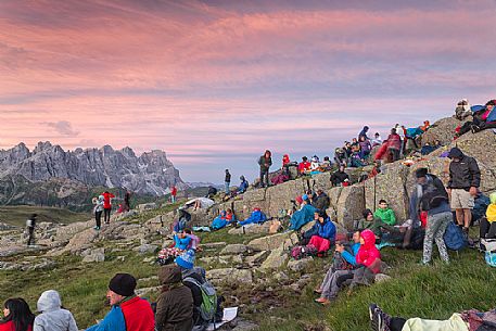 Sounds of the Dolomites, the high altitude music festival in Trentino.  At Sunrise many people listen to a concert on Col Margherita with Pale di San Martino Dolomites in background, dolomites, Italy