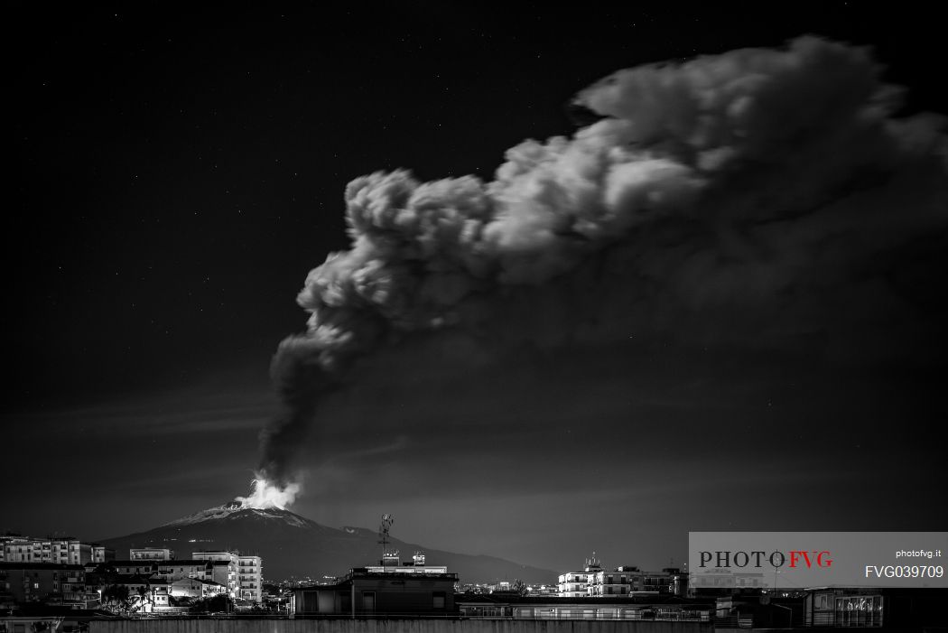 Nightscape of Catania town and the eruption of the Etna volcano, Sicily