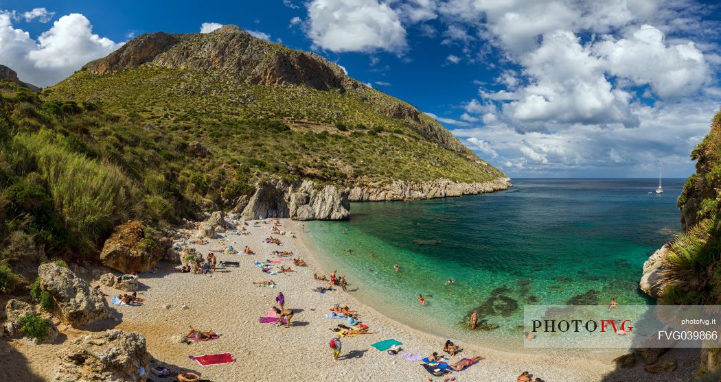 Tourists at the Cala Tonnarella dell'Uzzo beach, in the Zingaro nature reserve, Sicily, Italy