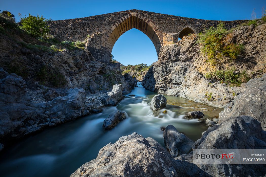 Front view of the ponte dei saraceni bridge, an ancient medieval bridge of Norman age located on the Simeto river, near Adrano, Catania, Sicily, Italy
