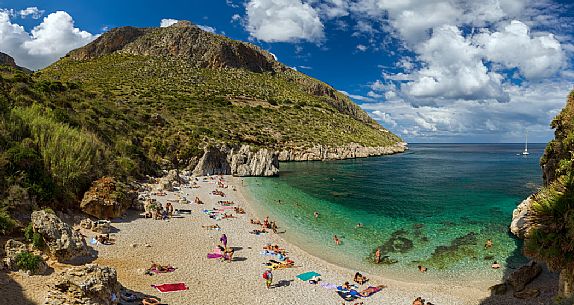 Tourists at the Cala Tonnarella dell'Uzzo beach, in the Zingaro nature reserve, Sicily, Italy