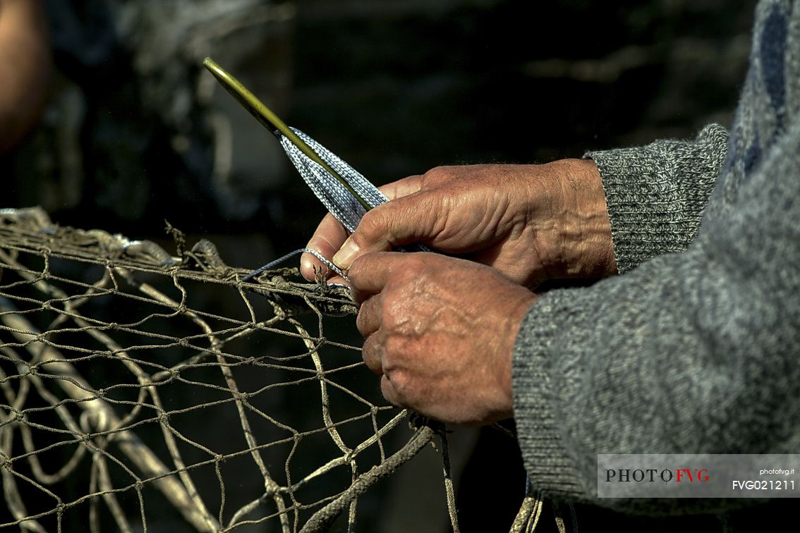 Repairing fishing nets in the harbour of Camogli, Little Tonnara of Camogli, Liguria, Italy