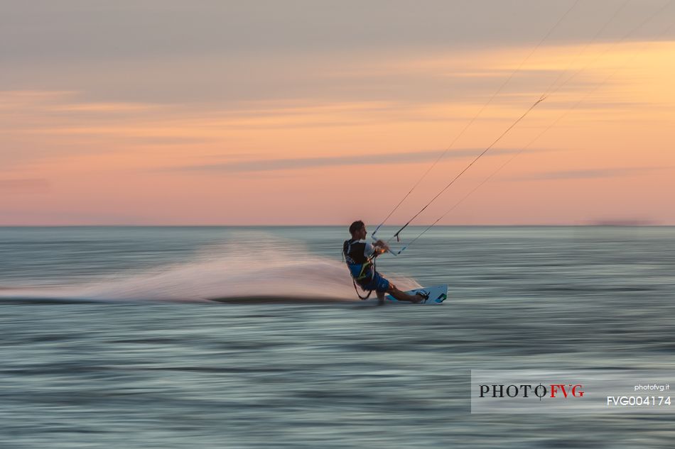 Kitesurfing running fast at sunset 