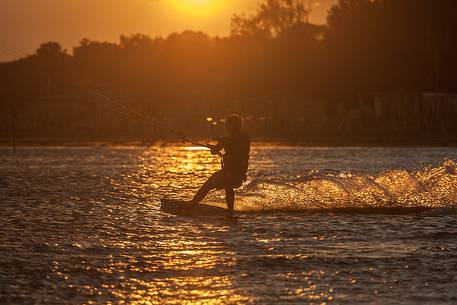 Kitesurfing running fast at sunset on the sea