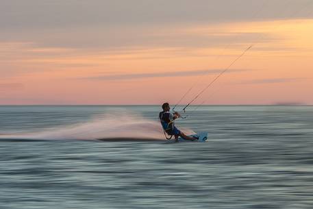 Kitesurfing running fast at sunset 