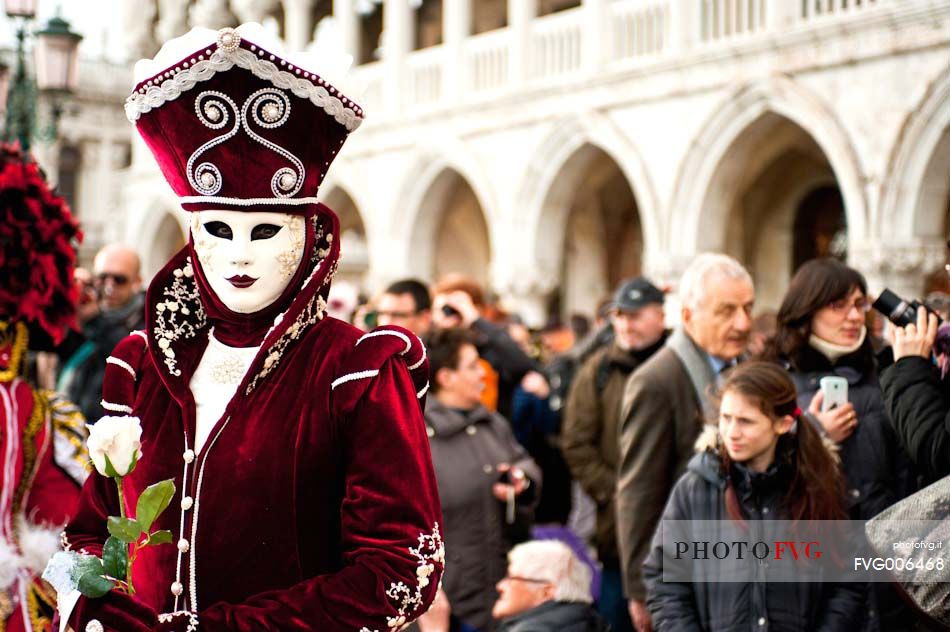 Tourists and carnival mask in San Marco square, Venice, Italy, Europe