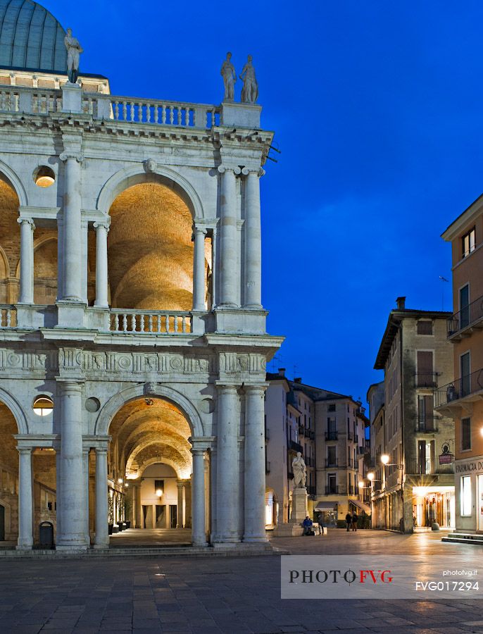The Basilica Palladiana is a Renaissance building in the central Piazza dei Signori in Vicenza at twilight. Beside the statue of the architect Andrea Palladio, Vicenza, Italy, Europe