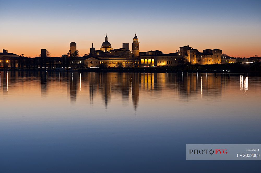 The profile of the city of Mantua, Unesco Heritage and Italian capital of culture, is reflected in the Middle Lake at sunset. Italy