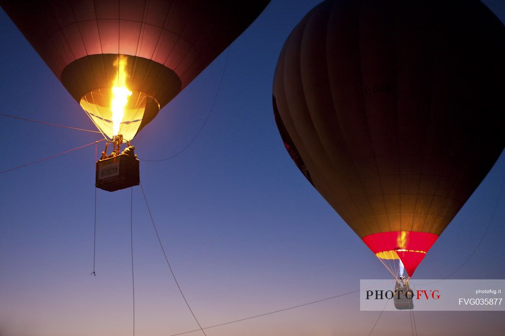 Illuminated hot air balloons in the sky at sunset. Balloon Festival of Udine, Friuli Venezia Giulia, Italy, Europe